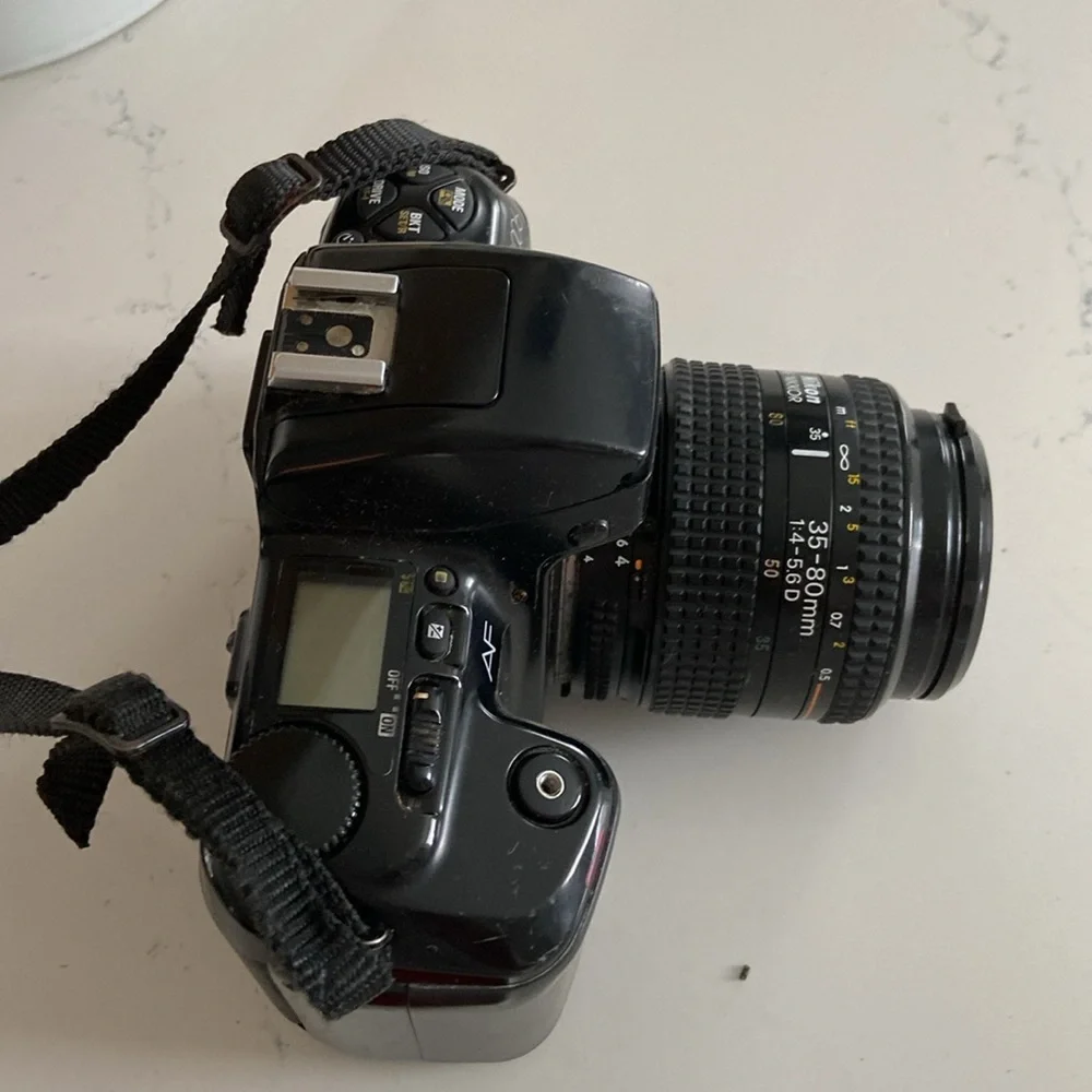 Nikon N6006 AF camera with lenses and leather bag.
